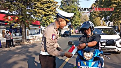 Polisi dan warga Jember mengibarkan bendera Merah Putih di jalan untuk sambut HUT RI ke-80