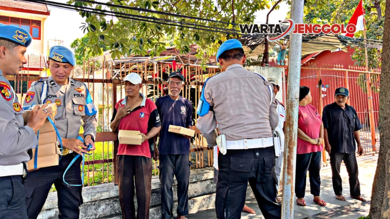 Polisi Polresta Banyuwangi membagikan nasi kotak kepada arga