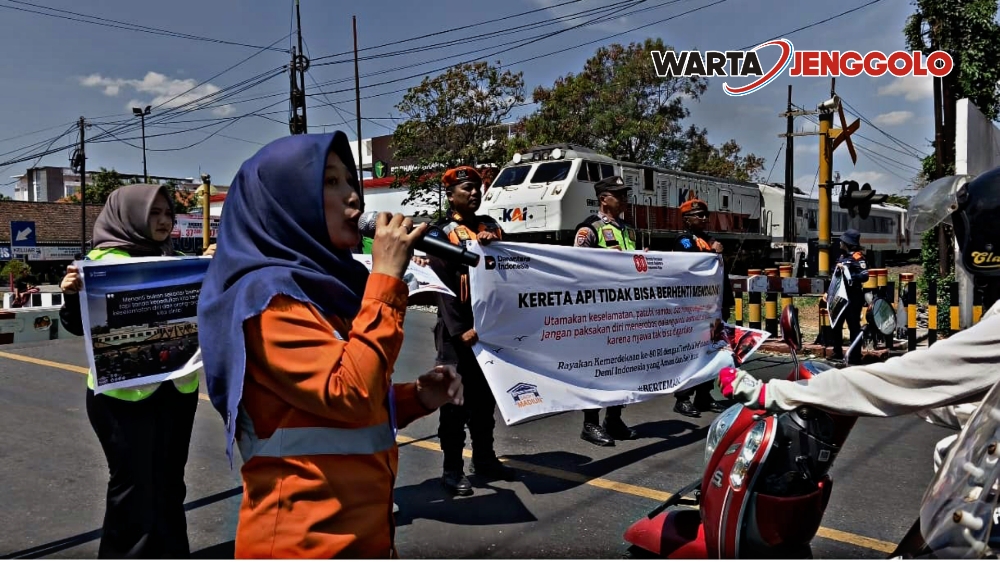 Petugas KAI Daop 7 Madiun memberikan edukasi keselamatan di perlintasan kereta api kepada warga setempat