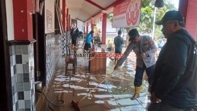 Polisi dan BPBD membersihkan area banjir di Malang Selatan.
