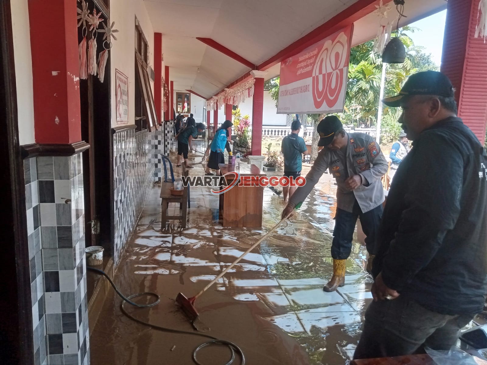 Polisi dan BPBD membersihkan area banjir di Malang Selatan.