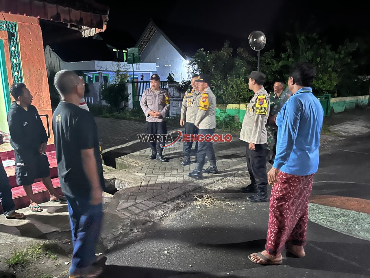 Kasi Propam Polres Kediri berbincang dengan warga saat patroli malam di Pos Satkamling Desa Dungus.