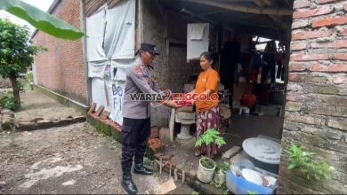Kapolsek Pagu menyerahkan bantuan sosial kepada warga dalam kegiatan bakti sosial.