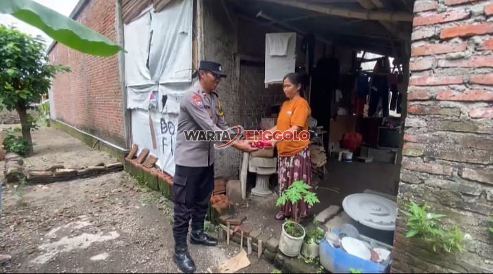 Kapolsek Pagu menyerahkan bantuan sosial kepada warga dalam kegiatan bakti sosial.
